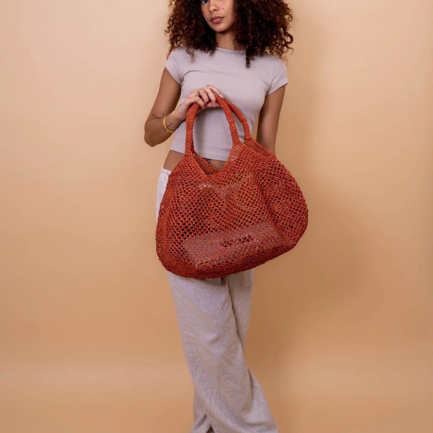Dale un toque original y veraniego a tu estilo con esta cesta calada hecha a mano en rafia natural. Su diseño ligero, fresco y colorido es perfecto para acompañarte en días de playa, escapadas urbanas o looks relajados de verano.
Elaborada con rafia natural y algodón, esta pieza combina tradición artesanal con un diseño contemporáneo. La rafia, fibra vegetal extraída de hojas de palma, conserva su textura natural y aporta un acabado único a cada cesta.