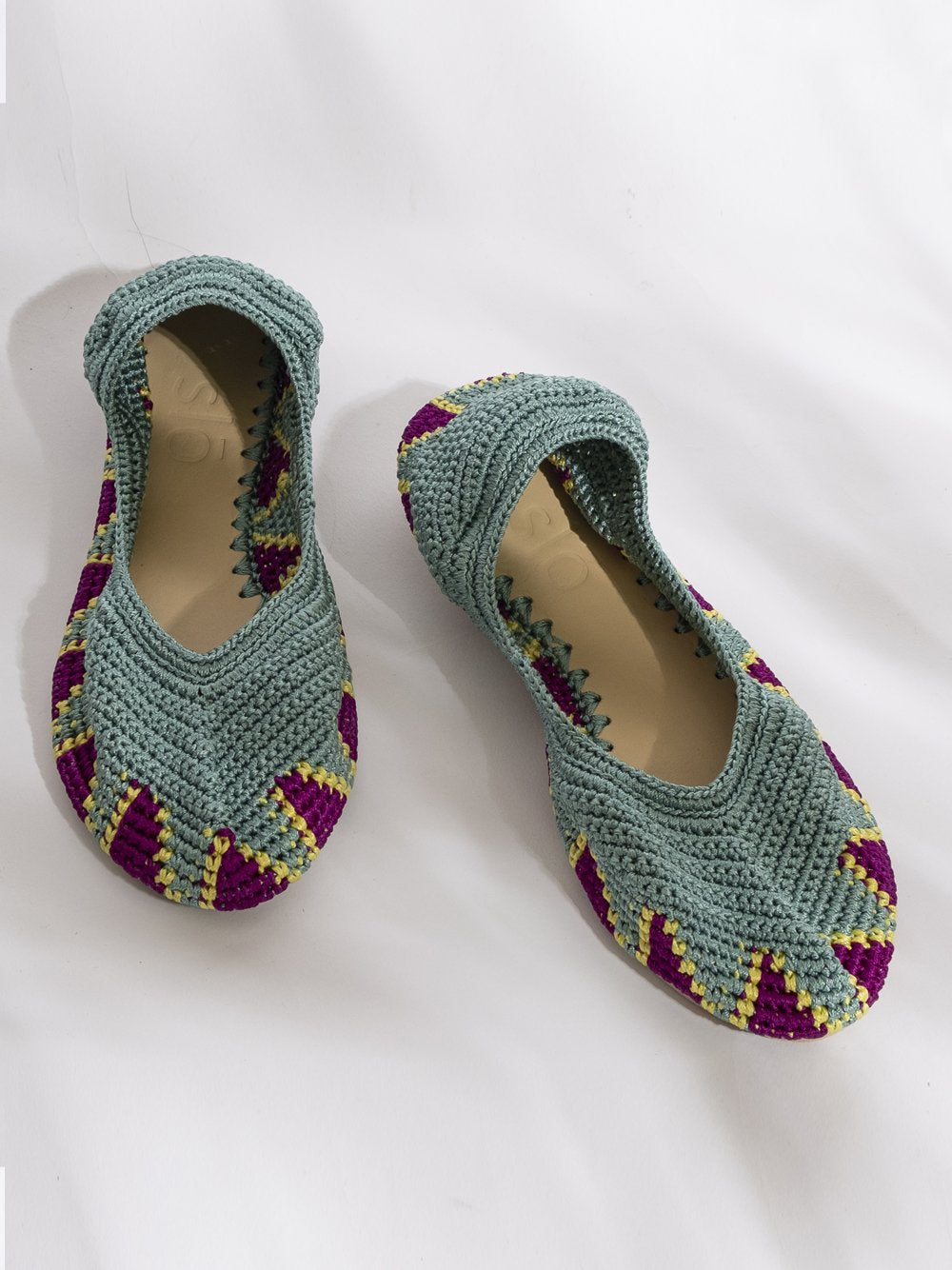 Bailarina de crochet slō hand made en color turquesa con detalles morados y amarillos, hecha a mano.